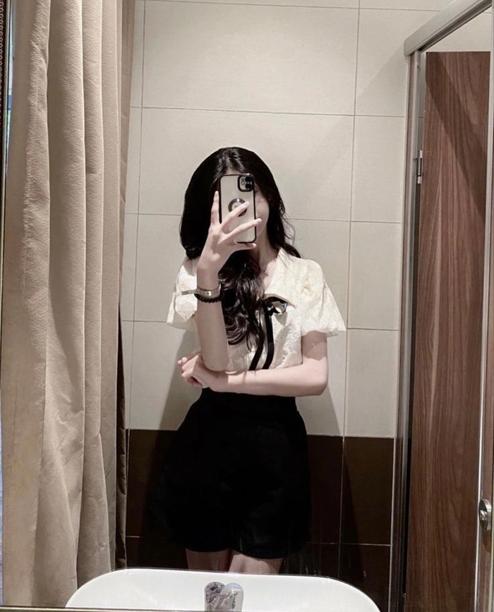 Ảnh cô gái che mặt bằng điện thoại trước gương